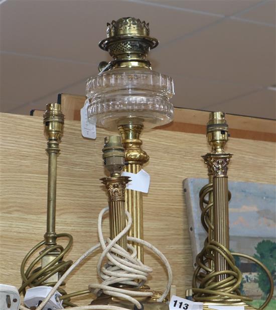 Four brass table lamps and an oil lamp